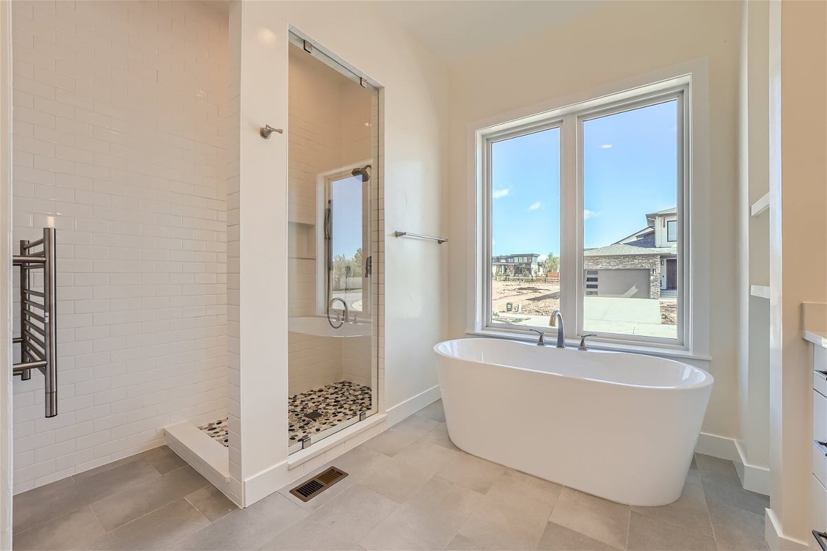 Bathroom with a freestanding bathtub next to a glass-enclosed shower room in a Sheffield Homes home in Westminster, CO