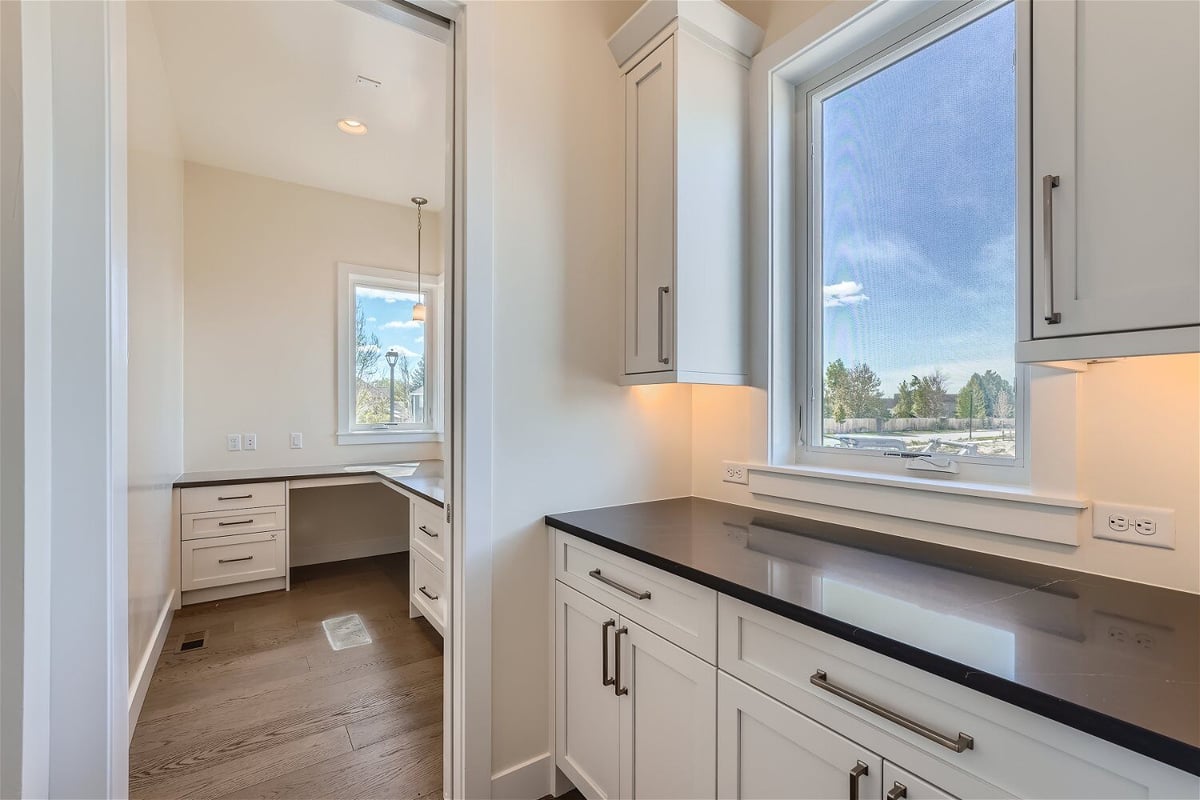 Bulter_s pantry with a black countertop and white wooden base cabinets in a Sheffield Homes home in Westminster, CO