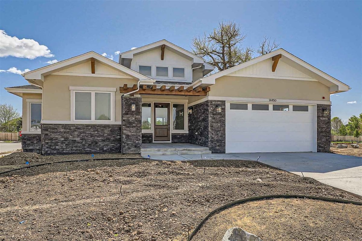 Daylight exterior front view of a custom home with a garage and front yard, built by Sheffield Homes in Westminster, CO