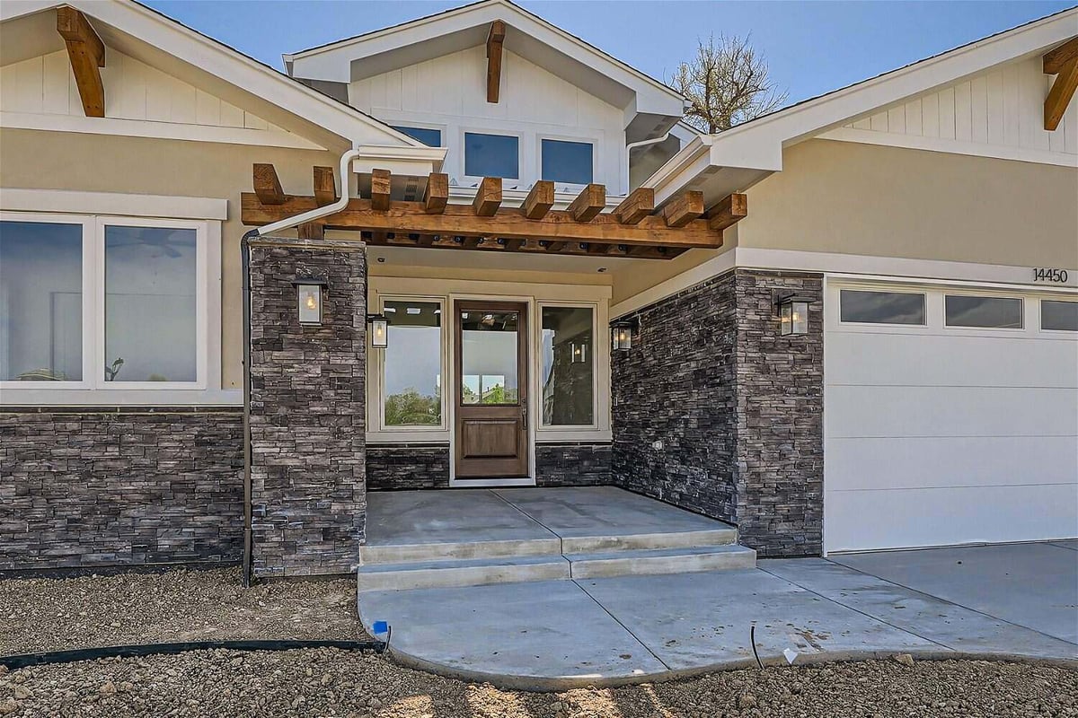 Exterior front entrance of a custom home featuring a main wood and glass door, by Sheffield Homes in Westminster, CO