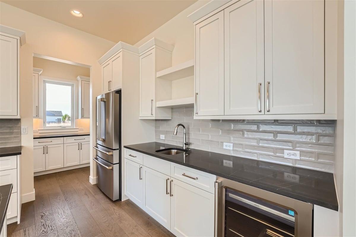 Kitchen with a rear counter and cabinets, and wall-mounted storage closet in a Sheffield Homes home in Westminster, CO