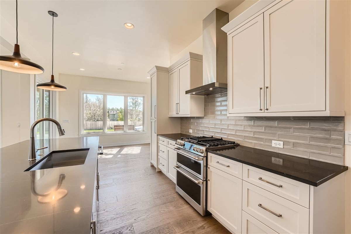 Kitchen with an island and a rear counter with modern stove fixtures and cabinetry, by Sheffield Homes in Westminster, CO(1)