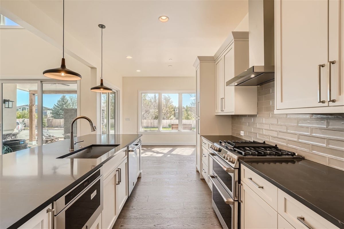 Kitchen with an island and a rear counter with modern stove fixtures and cabinetry, by Sheffield Homes in Westminster, CO