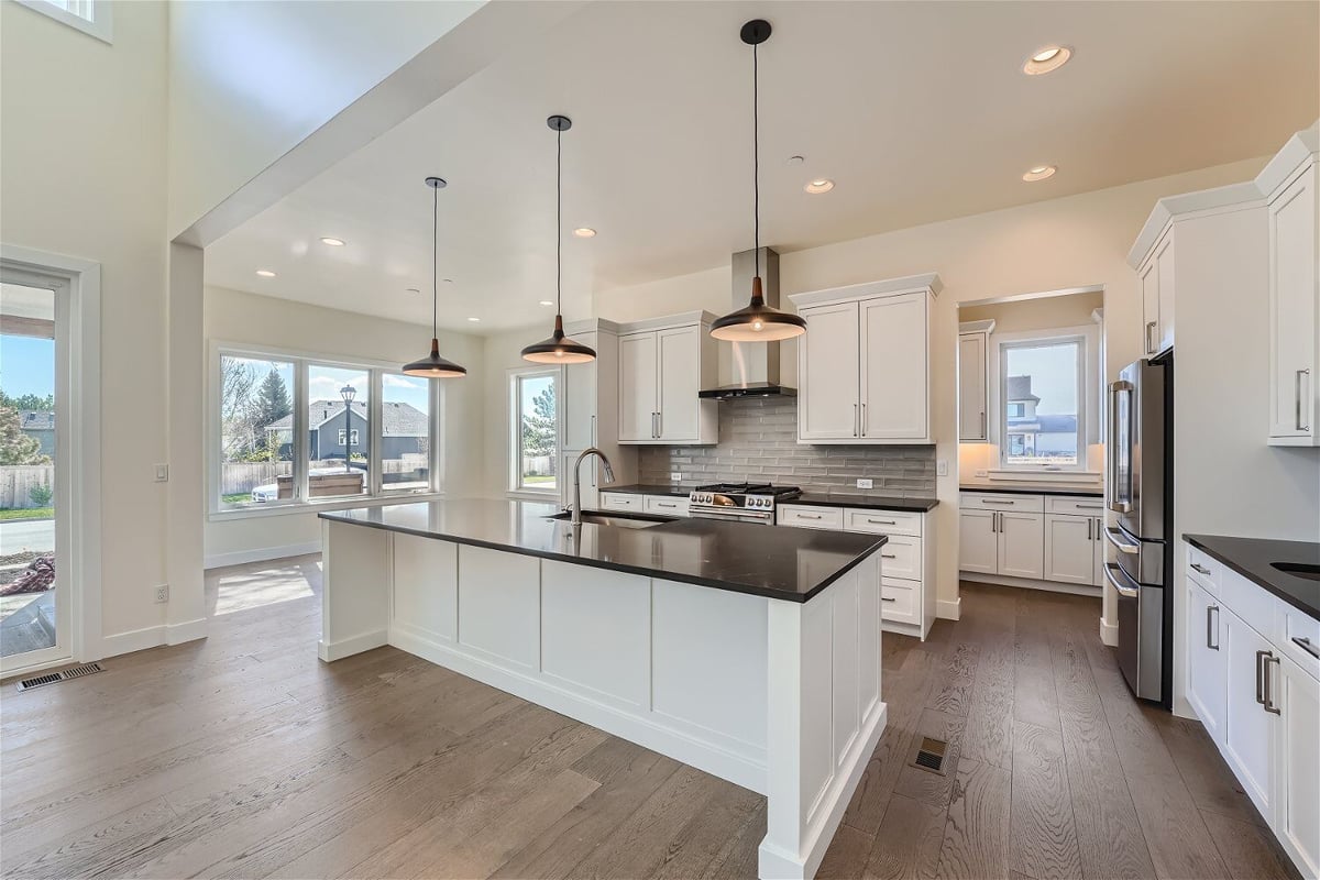 Kitchen with pendant lighting fixtures, a central island, and rear cabinetry in a Sheffield Homes home in Westminster, CO