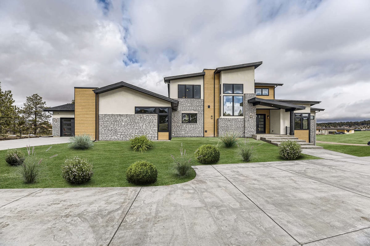 Contemporary custom home by Sheffield Homes in Denver, CO, featuring a mix of stone and wood accents on the exterior