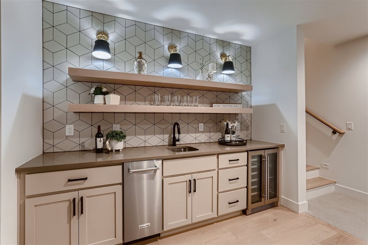 Finished basement wet bar with open shelving and geometric tile by Sheffield Homes in Denver, CO