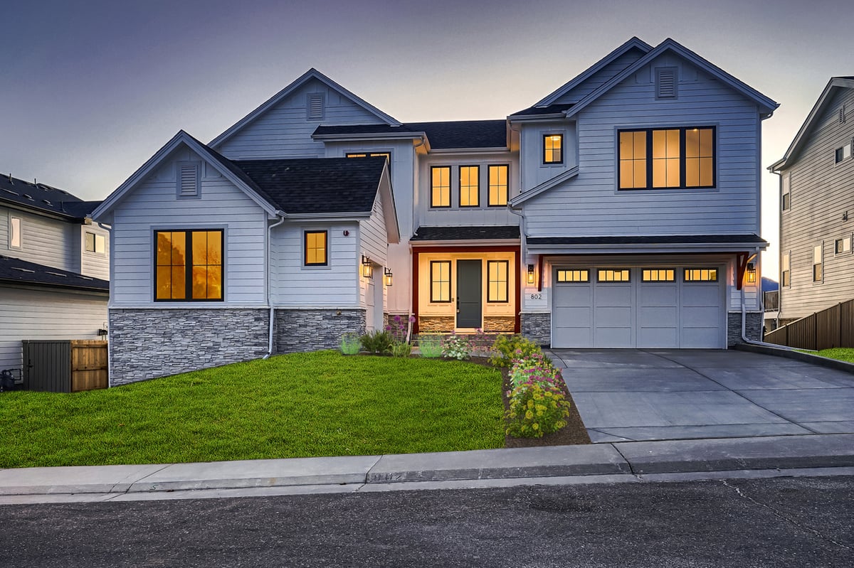 Evening view of elegant exterior lighting and garage of a custom home by Sheffield Homes in Denver, CO